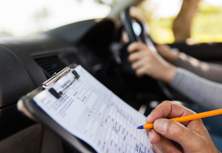 Driving instructor assessing learner with clipboard, DriveOn School of Motoring instructor driving course and intensive driving test preparation